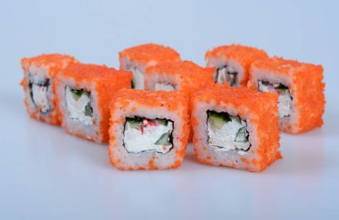 Deniz ürünleri ve balıklı renkli japon dürümleri hafif bir zemin üzerinde yatar.