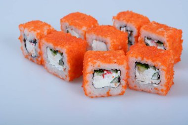 Deniz ürünleri ve balıklı renkli japon dürümleri hafif bir zemin üzerinde yatar.