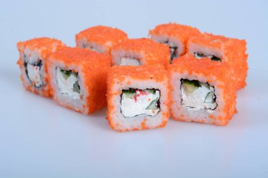 Deniz ürünleri ve balıklı renkli japon dürümleri hafif bir zemin üzerinde yatar.