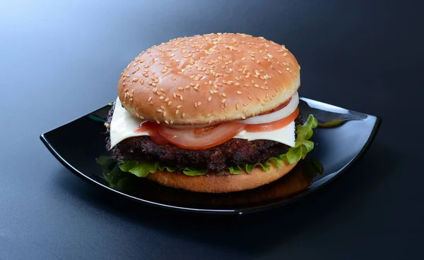 トマト キュウリ ハーブのジューシーなルディハンバーガーは暗い背景にあります — ストック写真
