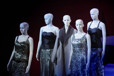 Beyaz kadın mankenler dikilip birbirlerine gözleriyle bakıyorlar.