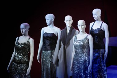 Beyaz kadın mankenler dikilip birbirlerine gözleriyle bakıyorlar.