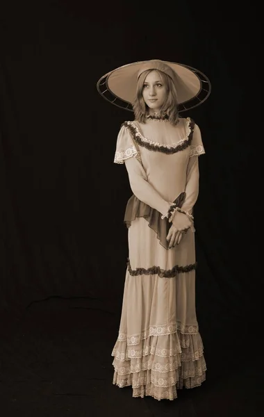 Ένα Κορίτσι Ένα Παλιό Φόρεμα Και Καπέλο Στέκεται Ένα Σκοτεινό — Φωτογραφία Αρχείου
