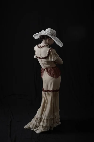 Ένα Κορίτσι Ένα Παλιό Φόρεμα Και Καπέλο Στέκεται Ένα Σκοτεινό — Φωτογραφία Αρχείου