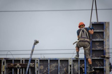 İşçiler ve inşaatçılar betondan yapılmış bir konut kompleksi inşa ediyorlar.