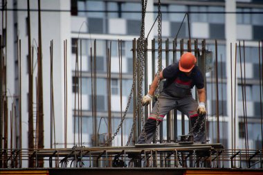 İşçiler ve inşaatçılar betondan yapılmış bir konut kompleksi inşa ediyorlar.