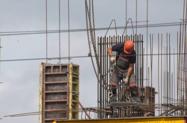 İşçiler ve inşaatçılar betondan yapılmış bir konut kompleksi inşa ediyorlar.