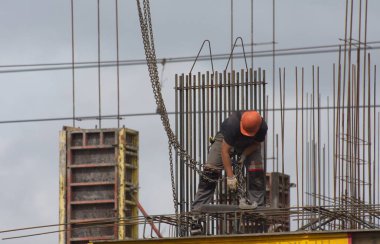 İşçiler ve inşaatçılar betondan yapılmış bir konut kompleksi inşa ediyorlar.