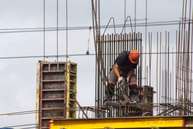 İşçiler ve inşaatçılar betondan yapılmış bir konut kompleksi inşa ediyorlar.