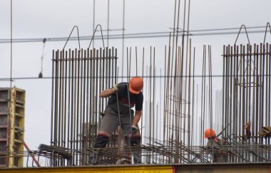 İşçiler ve inşaatçılar betondan yapılmış bir konut kompleksi inşa ediyorlar.