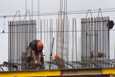 İşçiler ve inşaatçılar betondan yapılmış bir konut kompleksi inşa ediyorlar.