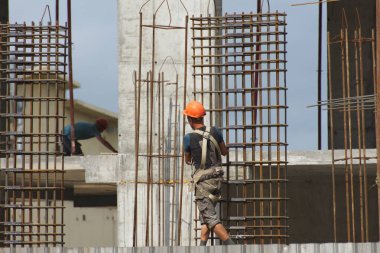 İşçiler ve inşaatçılar betondan yapılmış bir konut kompleksi inşa ediyorlar.