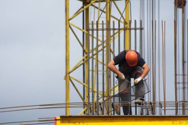 İşçiler ve inşaatçılar betondan yapılmış bir konut kompleksi inşa ediyorlar.