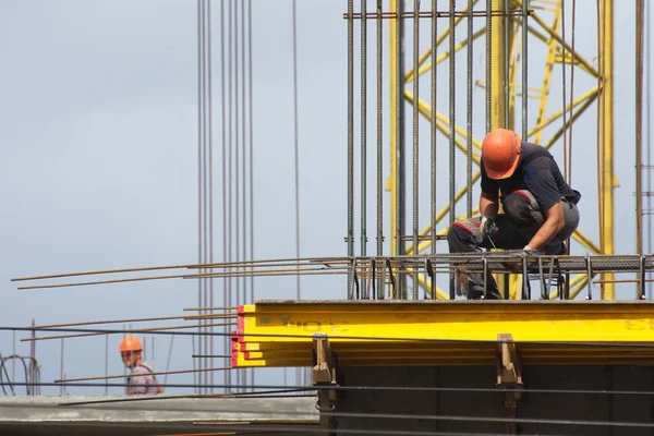 İşçiler ve inşaatçılar betondan yapılmış bir konut kompleksi inşa ediyorlar.