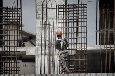 İşçiler ve inşaatçılar betondan yapılmış bir konut kompleksi inşa ediyorlar.