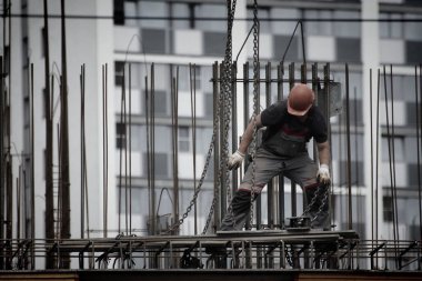 İşçiler ve inşaatçılar betondan yapılmış bir konut kompleksi inşa ediyorlar.