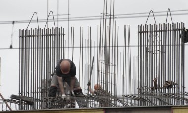  İşçiler ve inşaatçılar betondan yapılmış bir konut kompleksi inşa ediyorlar.