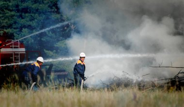 Barnaul, Rusya - 23 Ağustos 2021. İtfaiyeciler bir yaz günü koruma alanındaki bir orman yangınını söndürürler.