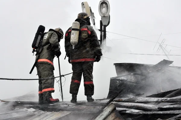 Los bomberos apagan la llama al fuego —  Fotos de Stock