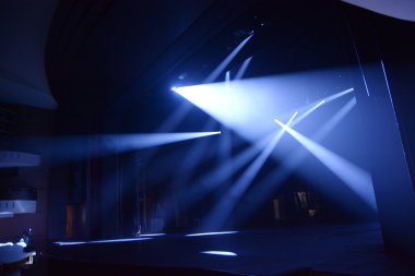 Rays of light on the stage during the show.on a dark background clipart