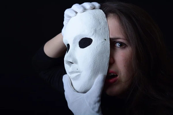 Egy barna lány, tartja fehér színházi maszk — Stock Fotó