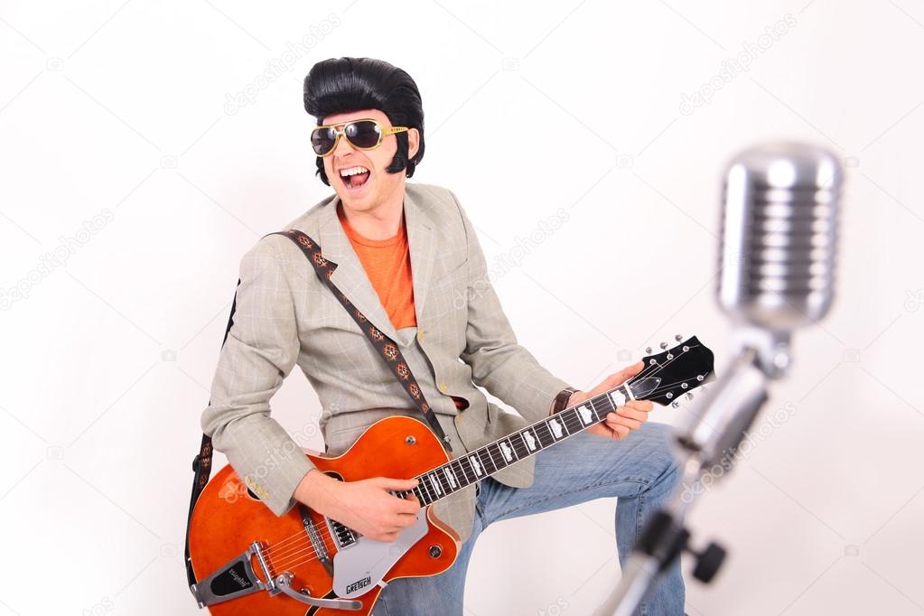 Elvis Presley plays guitar and sings
