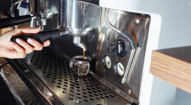 Kahvecide kahve makinesiyle kahve hazırlayan Barista. Bulanık resim, seçici odak