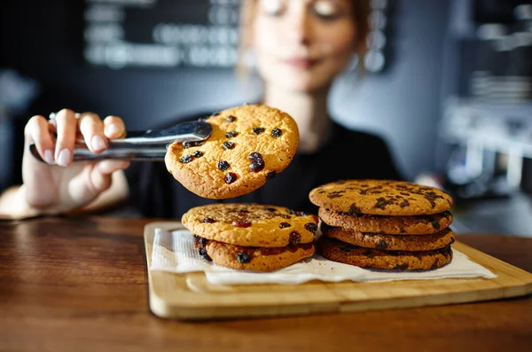 バリスタはコーヒーショップのバーカウンターでおいしいクッキーを持っています ぼやけた画像 選択的な焦点 — ストック写真
