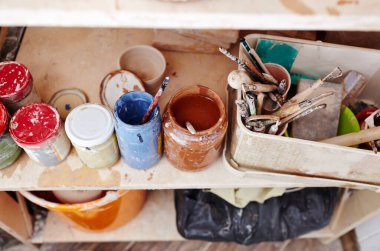 Çömlek aletlerinin, varyasyonların, boyaların ve iş yerindeki dekoratif resimler için boya fırçasının genel görünümü