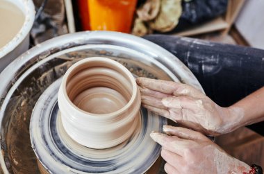 Kadının elleri kil kalıbı çıkarıyor. Potter çömlek atölyesinde seramik demlik yapıyor.