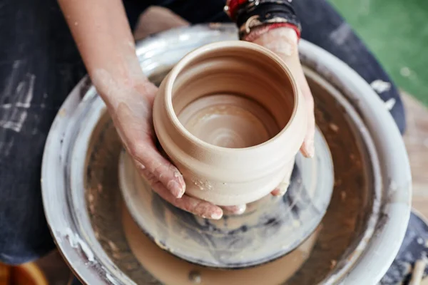 Kadının elleri kil kalıbı çıkarıyor. Potter çömlek atölyesinde seramik demlik yapıyor.