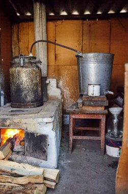 Eski metal ocak kapısı ve yanan odun. Açık ateşte büyük tencereyle eski usul yemek. Ahşap ateşte geleneksel pişirme görünür alevler ve dumanla