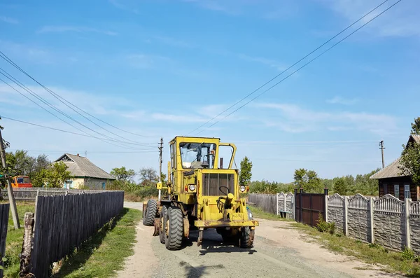 Road grader - heavy earth moving road construction equipment. Industrial motor grader on ground