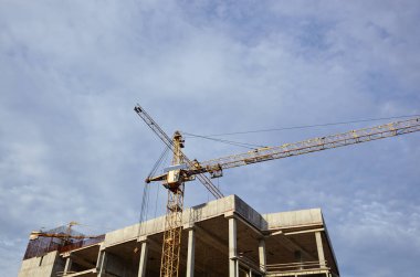 Kule vinci bir ev inşa ediyor. Beton bina yapım aşamasında. İnşaat alanı.