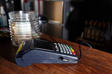 Kredi kartı ödeme terminali kahve dükkanının masasında. Temassız ödeme aygıtı, kart makinesinin yakın plan görüntüsü