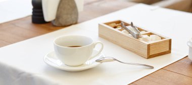 Tahta masadaki bir fincanda sıcak kahve. Modern tasarım iç mimari, restoran bulanık arkaplan ve bokeh resim