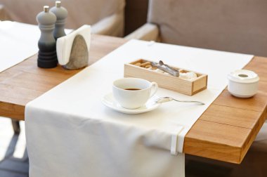 Tahta masadaki bir fincanda sıcak kahve. Modern tasarım iç mimari, restoran bulanık arkaplan ve bokeh resim