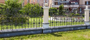 Demir çit döşedim. Güzel dekoratif döküm demir parmaklıklar, sanatsal demircilik ve taş sütunlar.