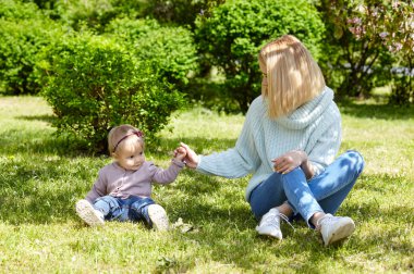 Anne ve kızı bahar parkında doğa yürüyüşünde. Küçük kız ve anne hafta sonu aktivitelerinde iyi vakit geçiriyorlar.