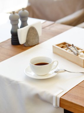 Tahta masadaki bir fincanda sıcak kahve. Modern tasarım iç mimari, restoran bulanık arkaplan ve bokeh resim