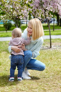 Anne ve kızı bahar parkında doğa yürüyüşünde. Küçük kız ve anne hafta sonu aktivitelerinde iyi vakit geçiriyorlar.
