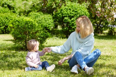 Anne ve kızı bahar parkında doğa yürüyüşünde. Küçük kız ve anne hafta sonu aktivitelerinde iyi vakit geçiriyorlar.