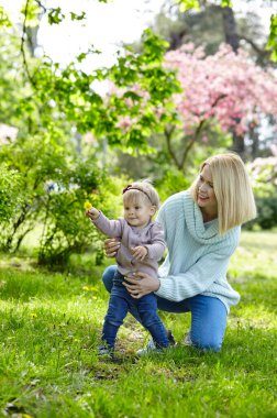 Anne ve kızı bahar parkında doğa yürüyüşünde. Küçük kız ve anne hafta sonu aktivitelerinde iyi vakit geçiriyorlar.
