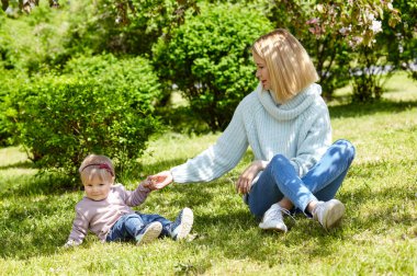Anne ve kızı bahar parkında doğa yürüyüşünde. Küçük kız ve anne hafta sonu aktivitelerinde iyi vakit geçiriyorlar.