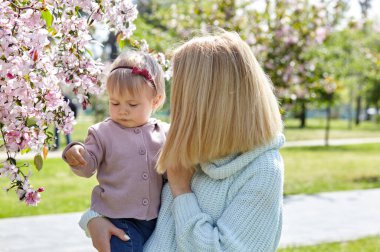 Anne ve kızı bahar parkında doğa yürüyüşünde. Küçük kız ve anne hafta sonu aktivitelerinde iyi vakit geçiriyorlar.