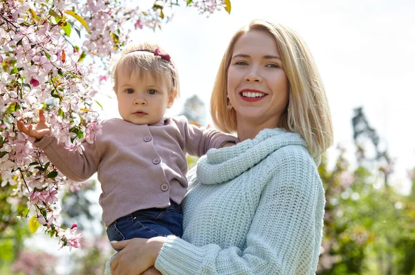 Mom and daughter on nature walk at spring park. Little girl and mother have a good time on weekend activity