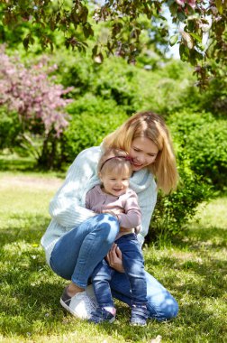Anne ve kızı bahar parkında doğa yürüyüşünde. Küçük kız ve anne hafta sonu aktivitelerinde iyi vakit geçiriyorlar.