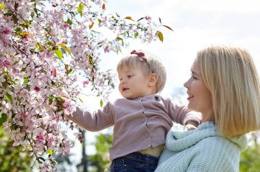 Anne ve kızı bahar parkında doğa yürüyüşünde. Küçük kız ve anne hafta sonu aktivitelerinde iyi vakit geçiriyorlar.