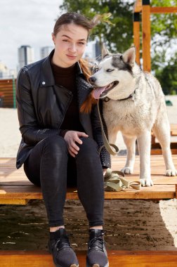 Sahibi kız parkta köpeğiyle dinleniyor. Bir köpekle bir kadının arkadaşlığı.