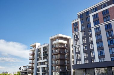 Güneşli bir günde mavi gökyüzü olan modern Avrupa konut binaları. Soyut mimari, modern şehir geometrisinin bir parçası